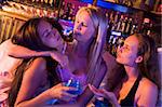 Two young women expressing concern over drunk friend at nightclu