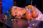 Drunk young woman resting head on bar counter