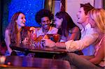 Group of young adults in a nightclub talking and laughing