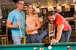 Young adults playing pool in a bar