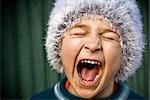 Close-up of portrait of crazy kid screaming loudly