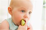 Baby eating apple indoors