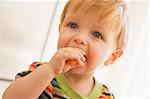 Young boy eating carrot indoors