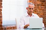 Businessman in office looking at laptop