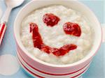 Bowl of Creamed Rice Pudding with a Strawberry Jam Face