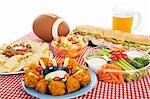 Table spread with appetizer trays for the footbal party.  Horizontal view over white background.