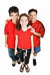 Teen couple and the girls father dressed in red, supporting their favorite sports team.  Full body isolated on white.