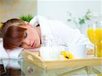 Beautiful woman in kitchen sleeping on table