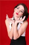 Beautiful Female Model Posing With Her Hands on Red Background