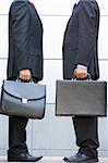 Two businessmen holding briefcases outdoors
