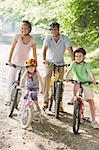 Family sitting on bikes on path smiling