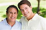 Two men standing outdoors smiling