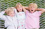 Three children relaxing and sleeping in hammock