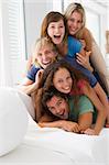 Five people in living room piled up smiling