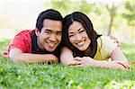 Couple lying outdoors smiling