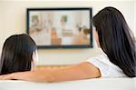Woman and young girl in living room with flat screen television