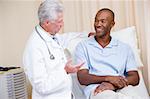 Doctor giving smiling man checkup in exam room