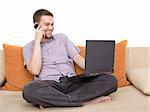 casual guy sitting on sofa with laptop