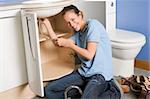 Plumber working on sink smiling