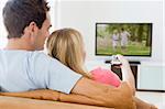 Couple in living room watching television