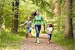 Mother and daughters skipping on path smiling