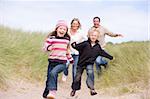 Family running on beach smiling