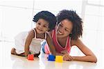 Mother and daughter indoors playing and smiling