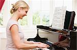 Woman playing piano and smiling