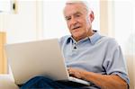 Man in living room with laptop smiling