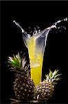 View of fresh pineapple juice splashing out of glass