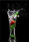 View of soft drink splashing out of glass on black back