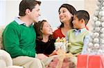 Family Smiling At Each Other,Holding Christmas Gift