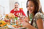 Grandfather And Granddaughter Sitting Down For Christmas Dinner