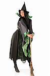 witch in green and black witch dress with broom and hat posing