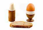 a soft boiled egg, a slice of bread and a saltpot
