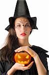 cute girl with witch hat and a little pumpkin betweeen hands