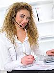 Beautiful business woman using headset in office