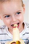 close up of healthy boy eating banana