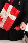 Man makes a christmas or other special occasion purchase with a gift card or credit debit card.  Focus to hand, shallof dof.