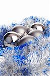 Several metallic matt and shiny Christmas balls with silver and blue tinsel