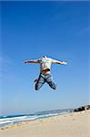 Man jumping on the beach and having fun