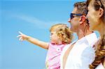 view of young family hanging out in summer environment. Focused on baby’s face.