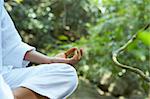 Fragment like image of young woman practicing yoga in tropic environment