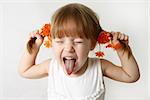 Head and hands shot of Little girl sticking out her tongue at the camera for fun