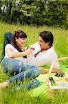 couple having a picnic in a park, smiling