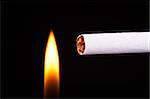Light a cigarette with a match, black background