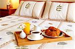 Tray with breakfast on a bed in a hotel room