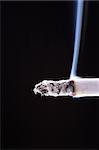 Burning cigarettes, black background