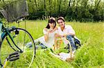 couple having a picnic in a park, smiling and looking at the camera