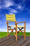 Wooden balcony with a chair and in the background a beautiful green meadow